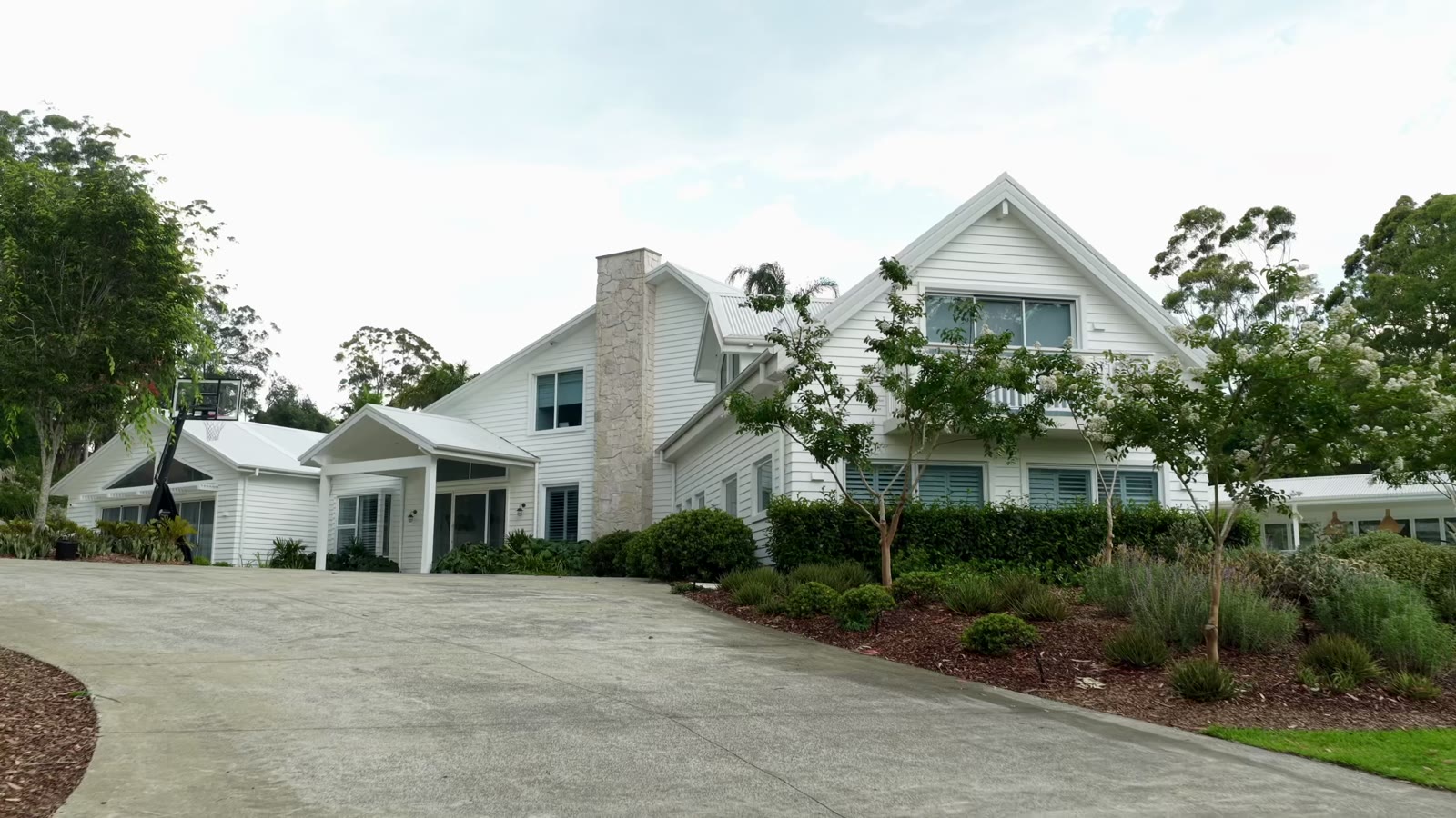 A home framed by landscaped gardens and a pond